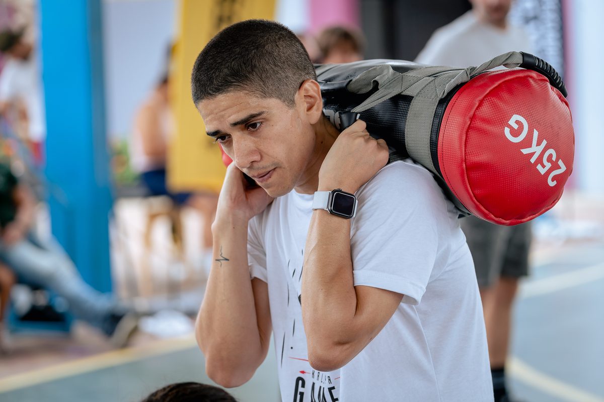 Atleta cargando un saco de 25 kg al hombro